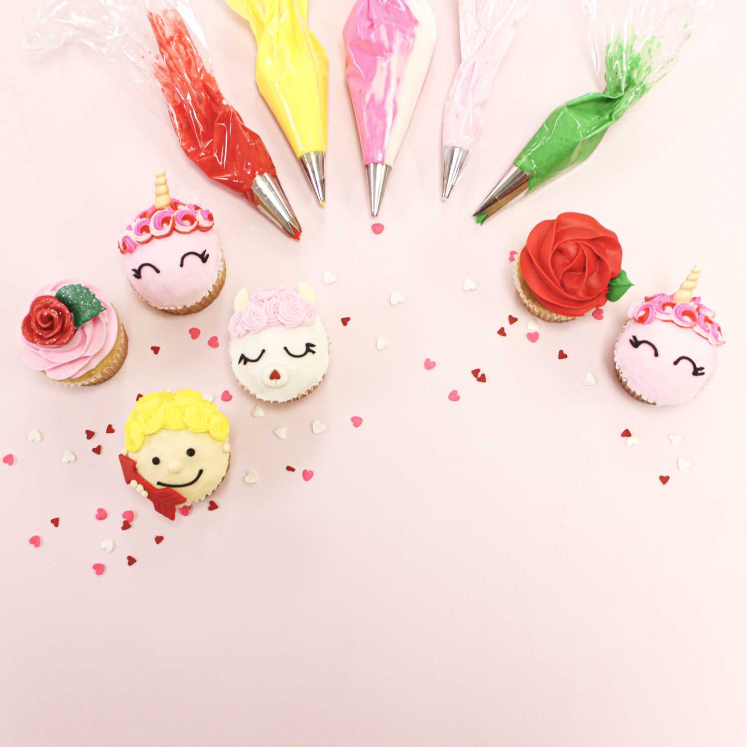 collection of valentine's day themed cupcakes, llama, cupid, roses, unicorns.
