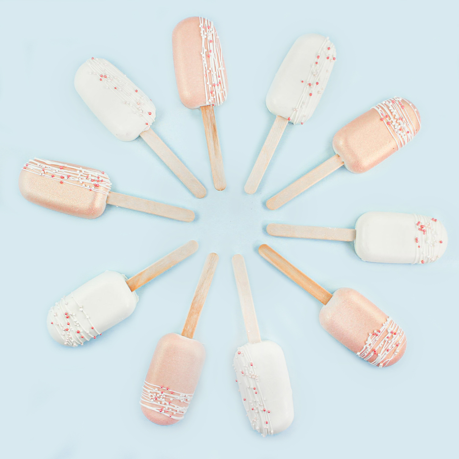 Rose gold and white cakesicles arranged into a circle