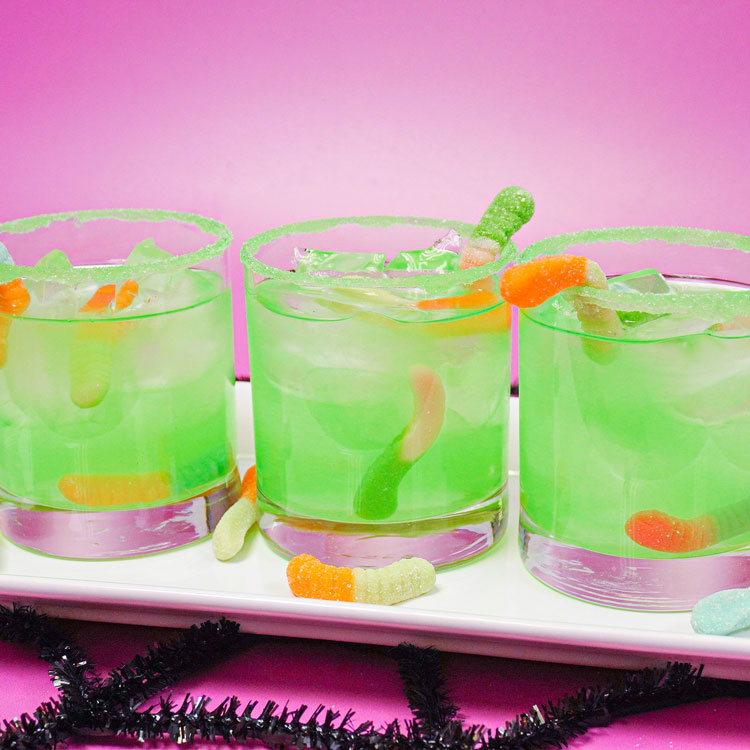 close-up of green halloween drinks with sour gummies