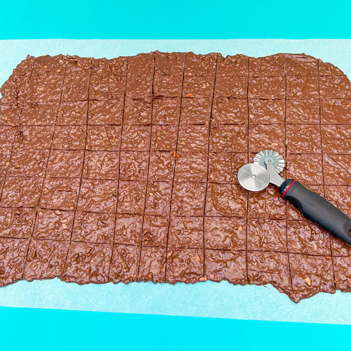scoring chocolate bark with pizza cutter for squares