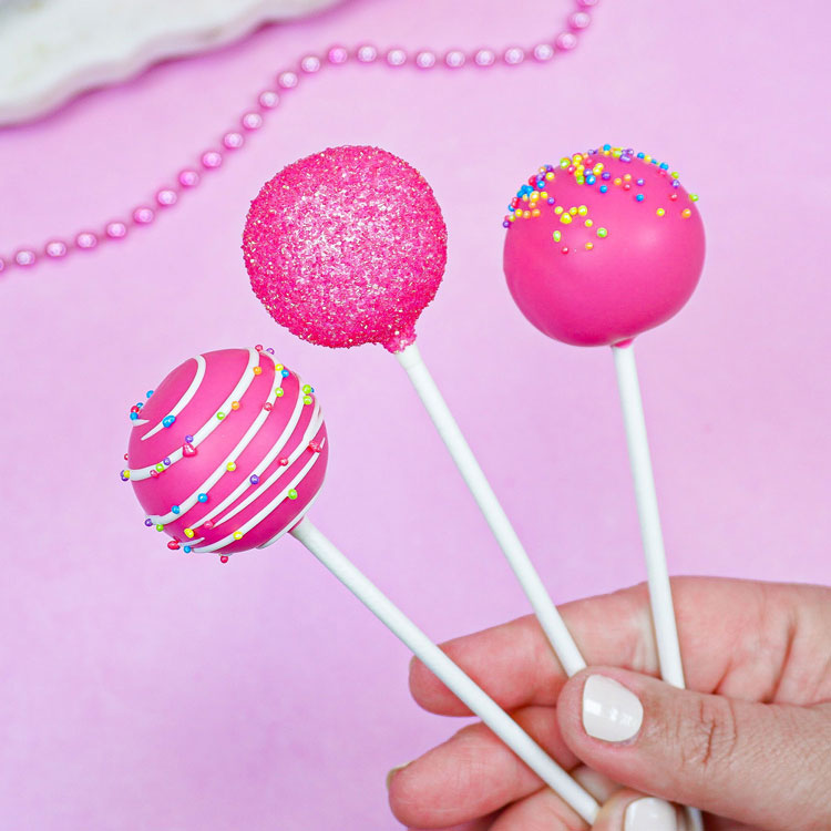 three decorated pink cake pops