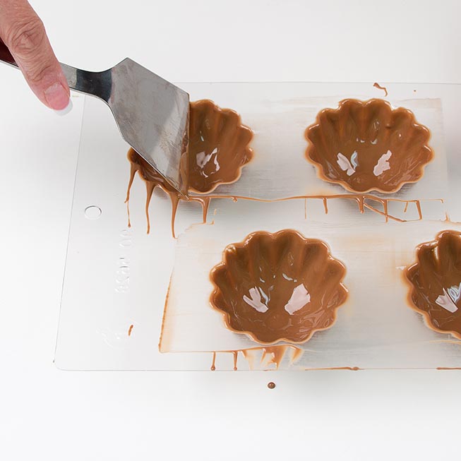 invert mold an use a spatula to scrape all excess candy off the surface of the mold.