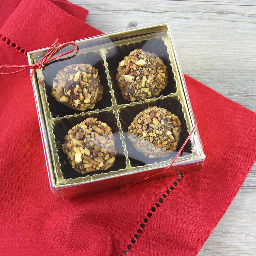 Pistachio Ganache Truffles packaged in a 4-piece candy box witha red metallic loop.