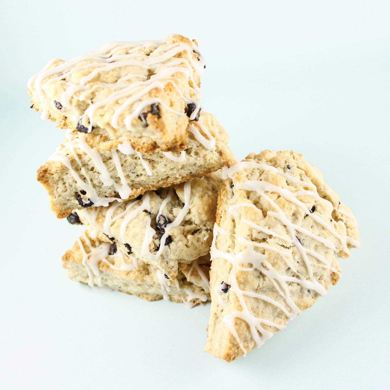 stack of blueberry scones with lemon drizzle by sugar and crumbs