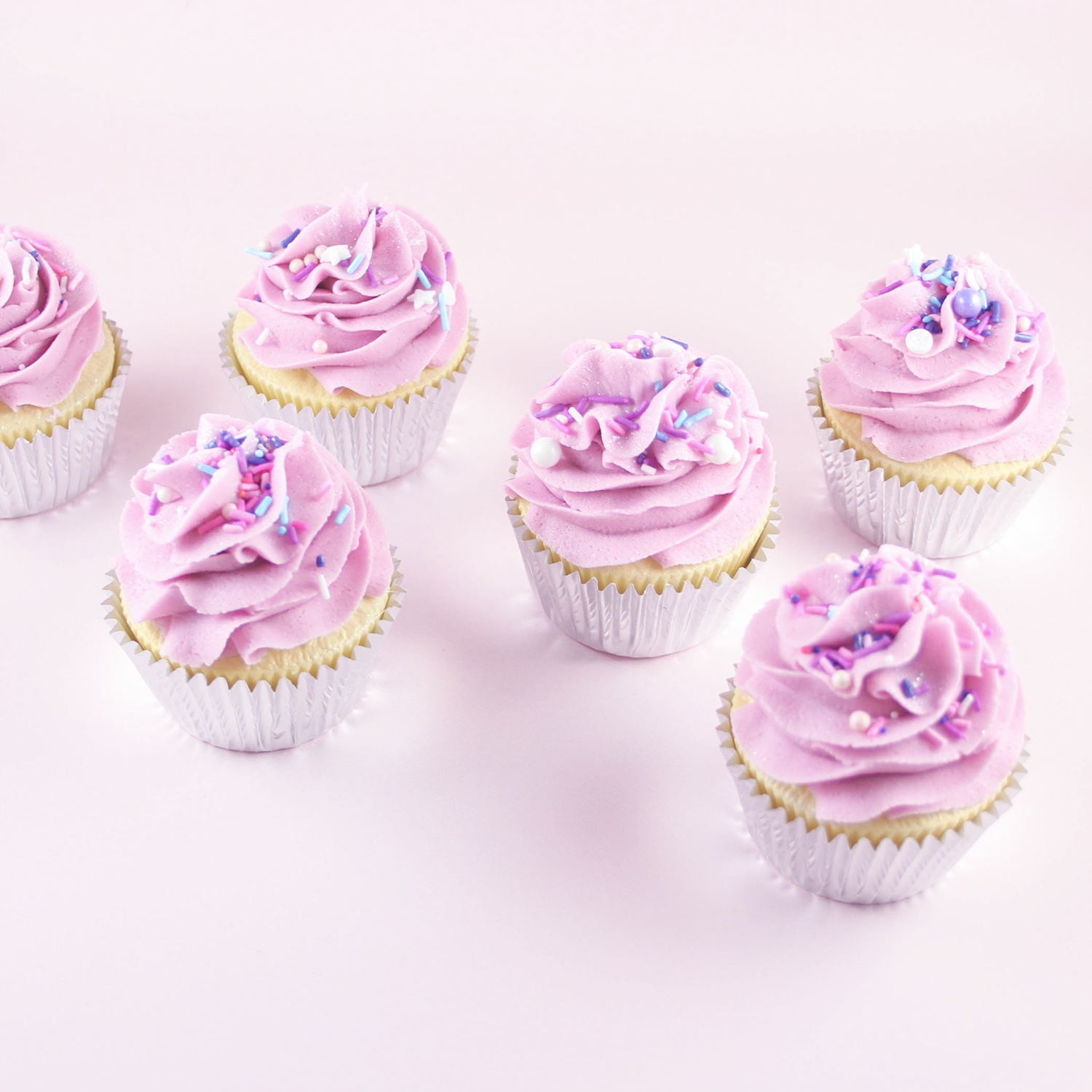 Cupcakes with a swirl of Raspberry Ripple Buttercream, sprinkles and jewel dust for sparkle.