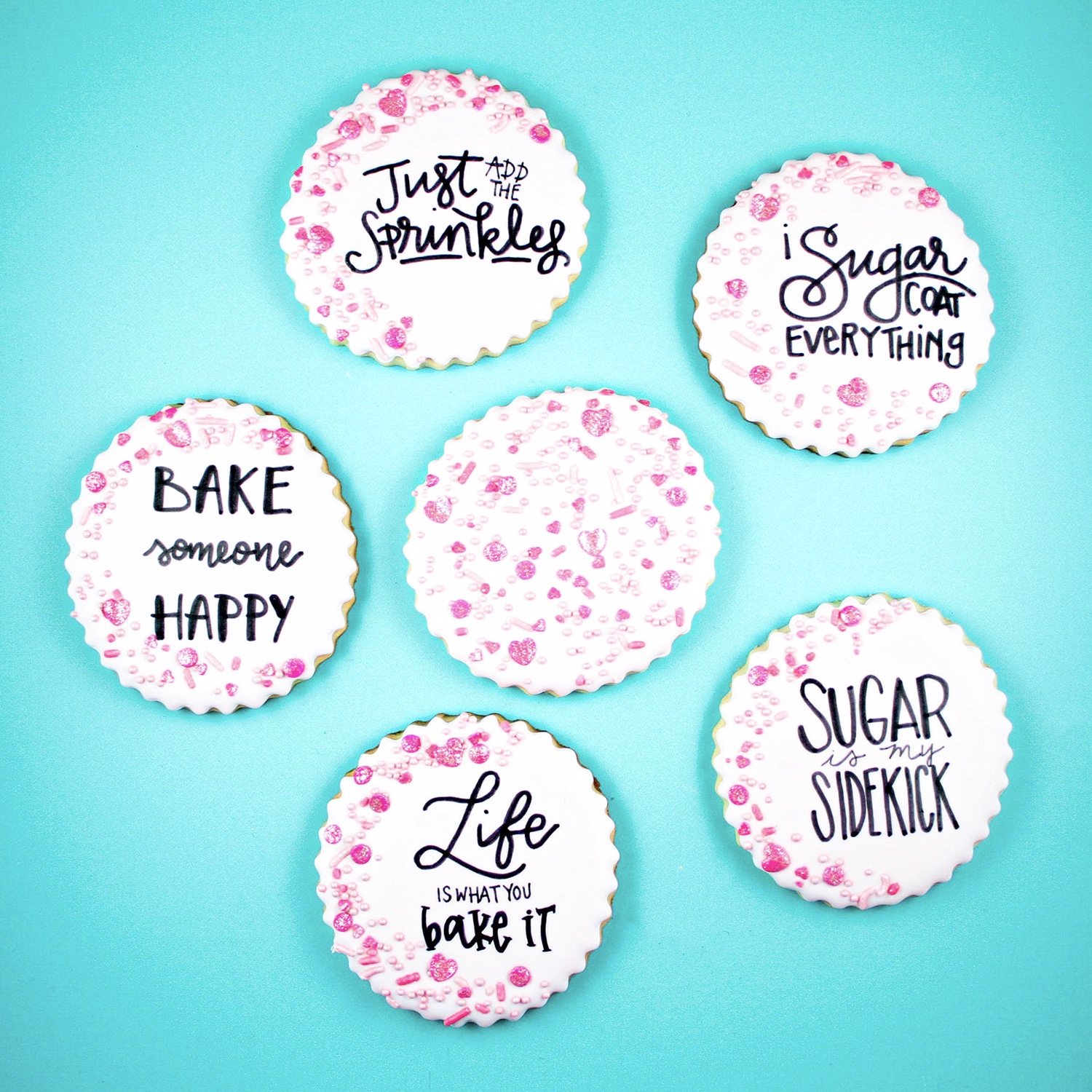 Scalloped baked cookies with strawberry milkshake royal icing, pink sprinkle mix and quotes about sugar.