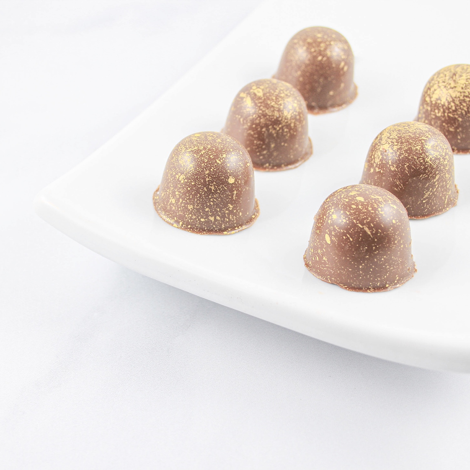 Banana Caramel Molded Truffles and splattered with edible gold paint.