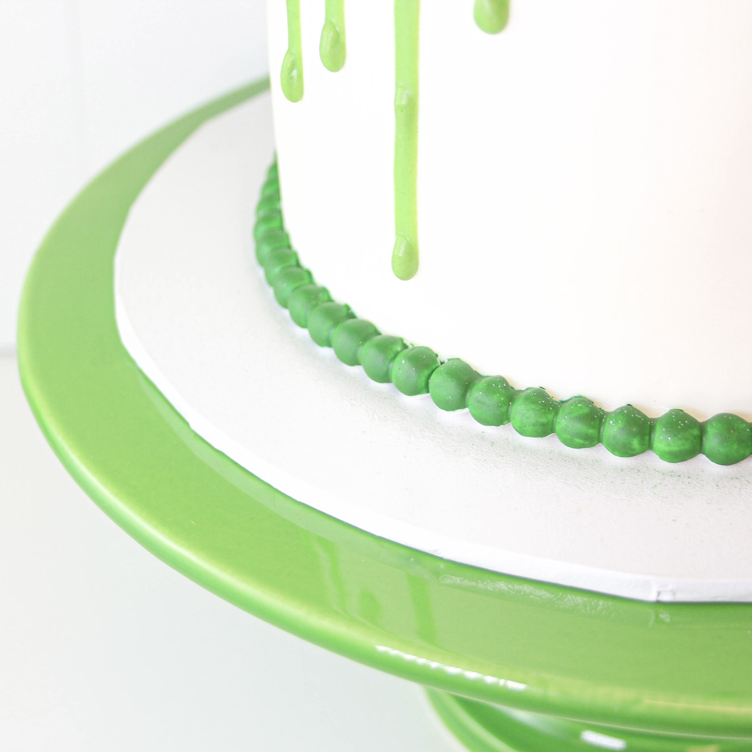 Green Drip Cake with green pearl border at bottom of cake