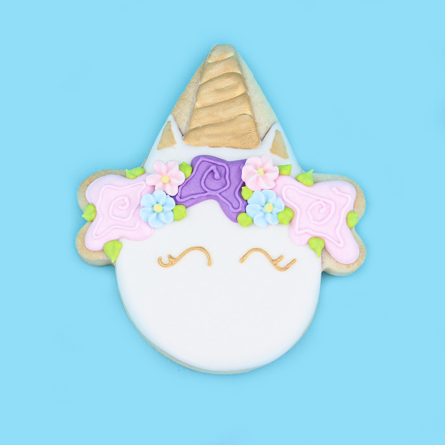 Unicorn decorated sugar cookie in royal icing usinga ice cream cone cookie cutter.