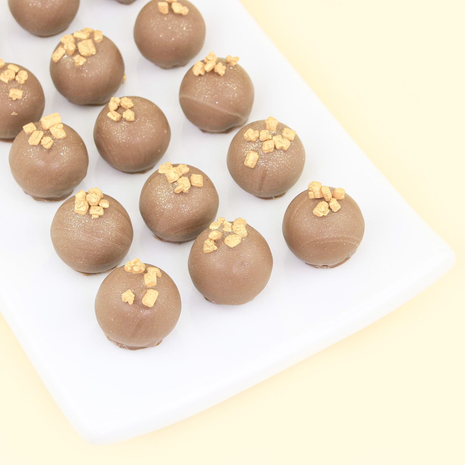 Milk chocolate Honey Truffles lined up on a plate