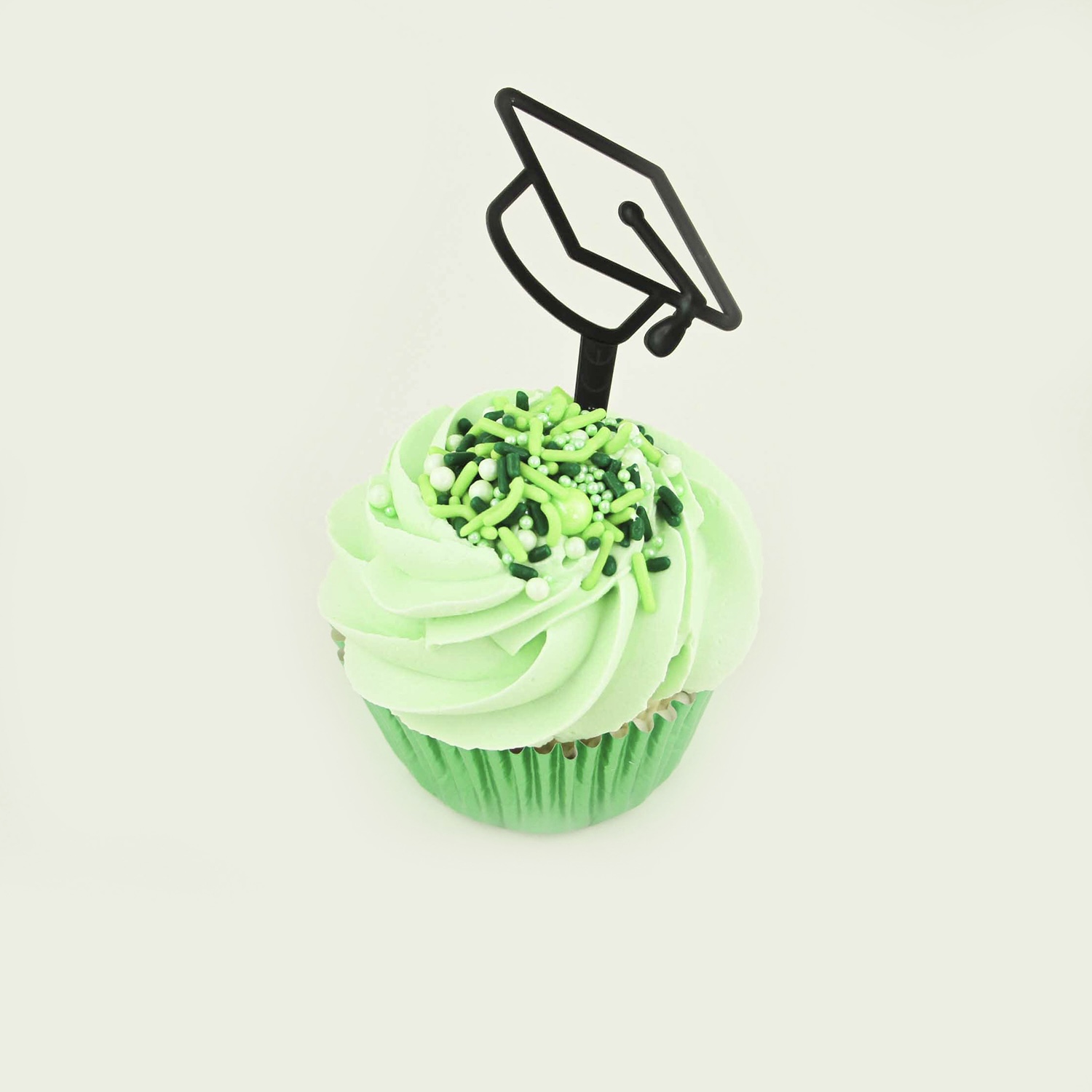 Green swirled buttercream with green coordinating sprinkles and a graduation hat cupcake topper.