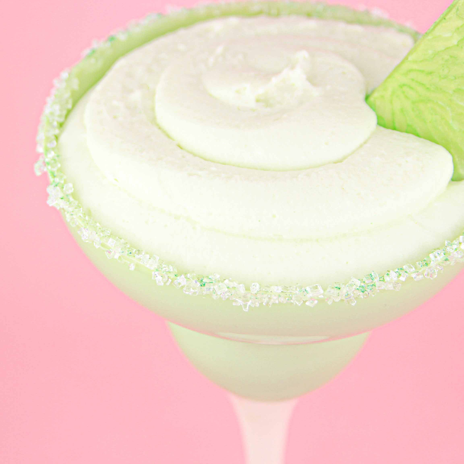 White Chocolate Margarita Glass rimmed with coarse sugar and green diamond dust. The glass is filled with a margarita mousse made from key lime pastry filling mixed with some margarita extract. and adorned with a chocolate made lime wedge.