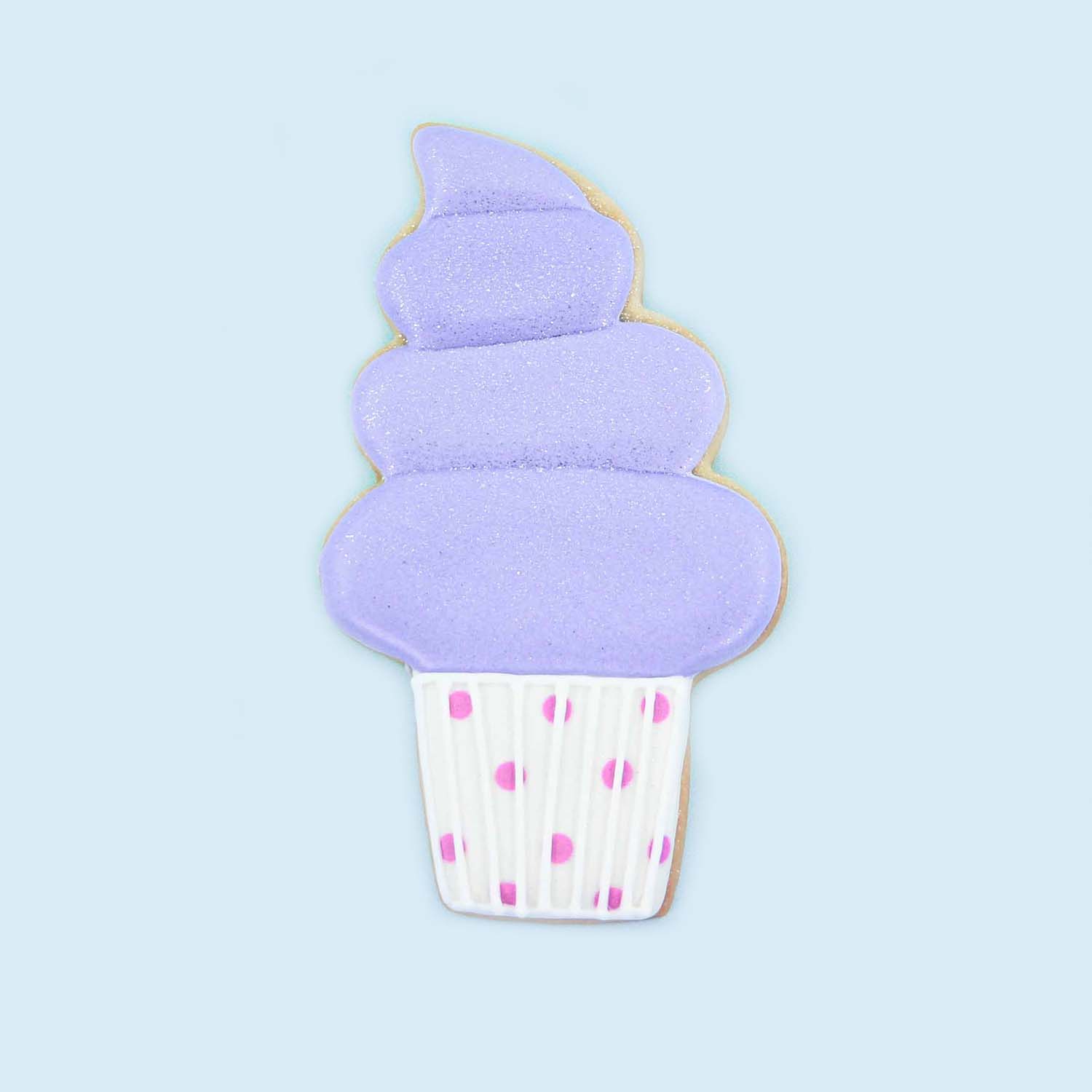 Purple soft serve ice cream with white sugar cone with purple polka dots cookie decorated in royal icing.