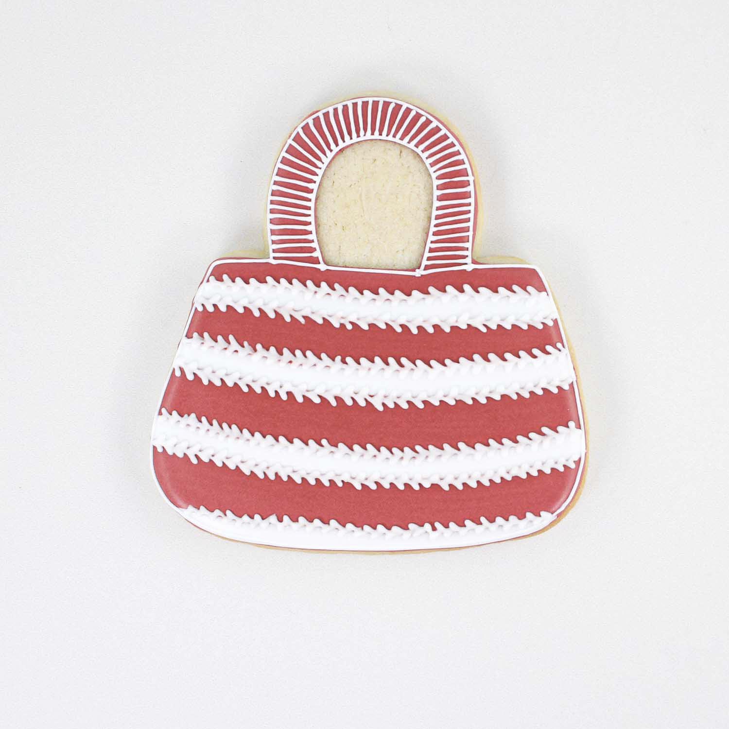 Stylish red and white striped tote bag cookie decorated in royal icing.