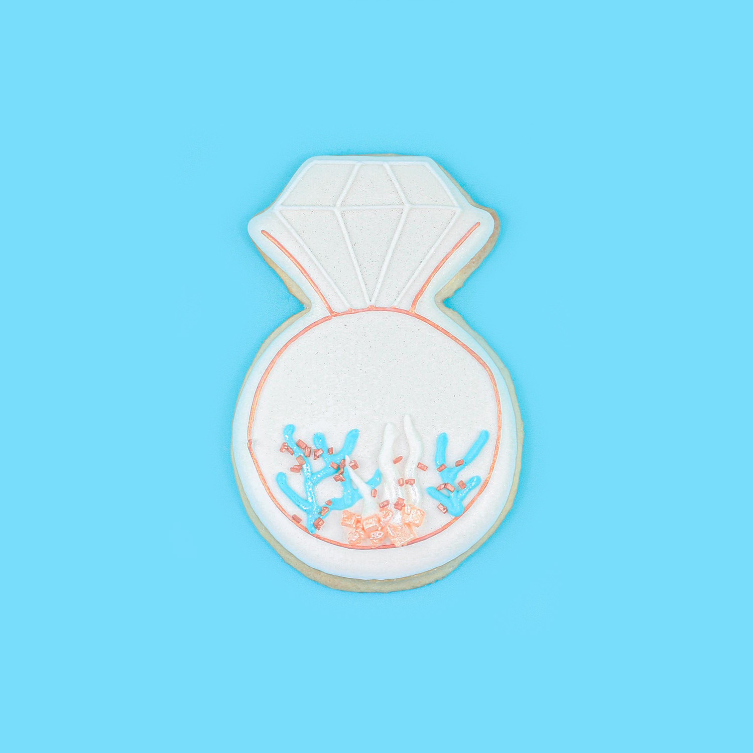 Engagement ring cookie decorated in royal icing with a coral reef motif.