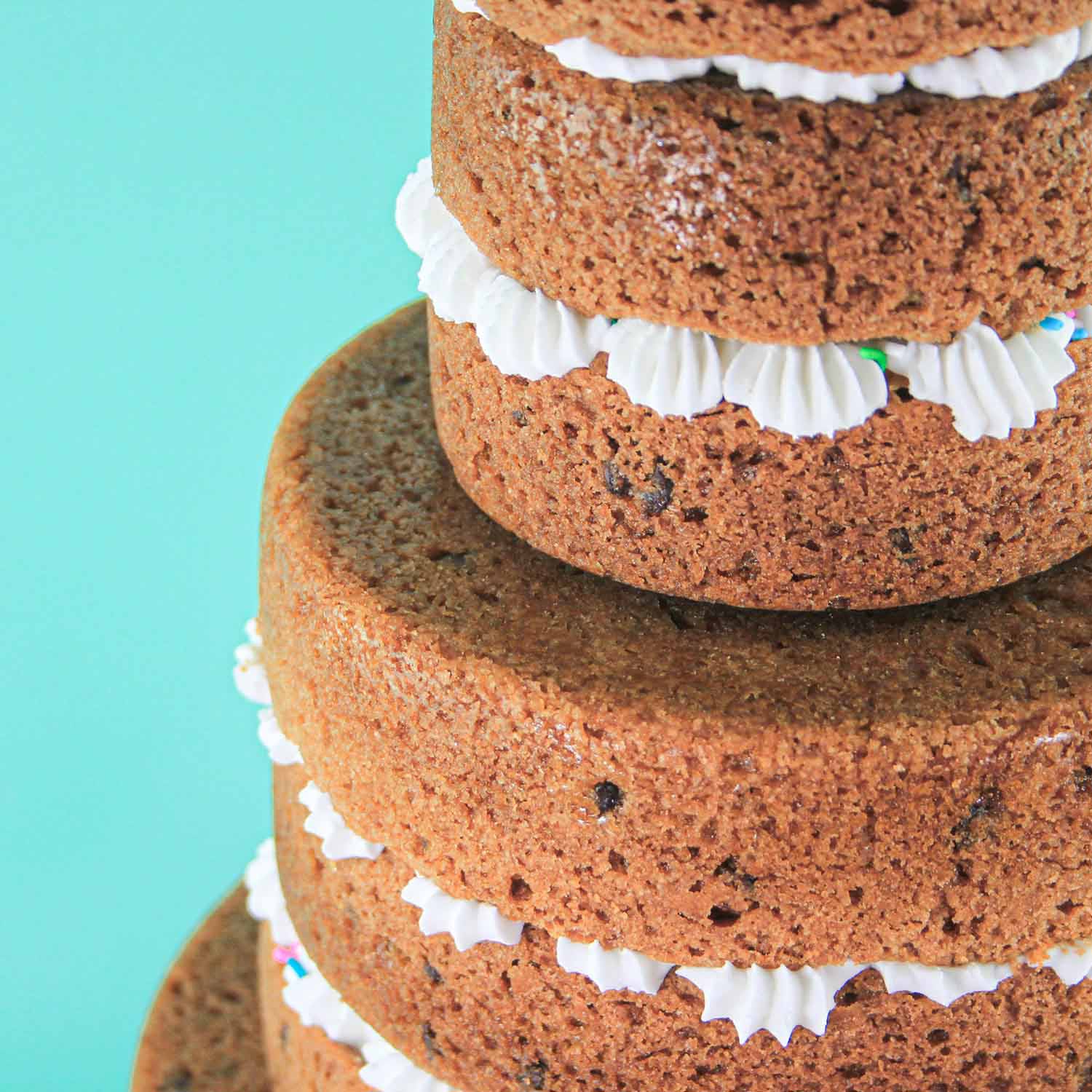 Showing the piped dollops of buttercream in between the cookie cake layers.