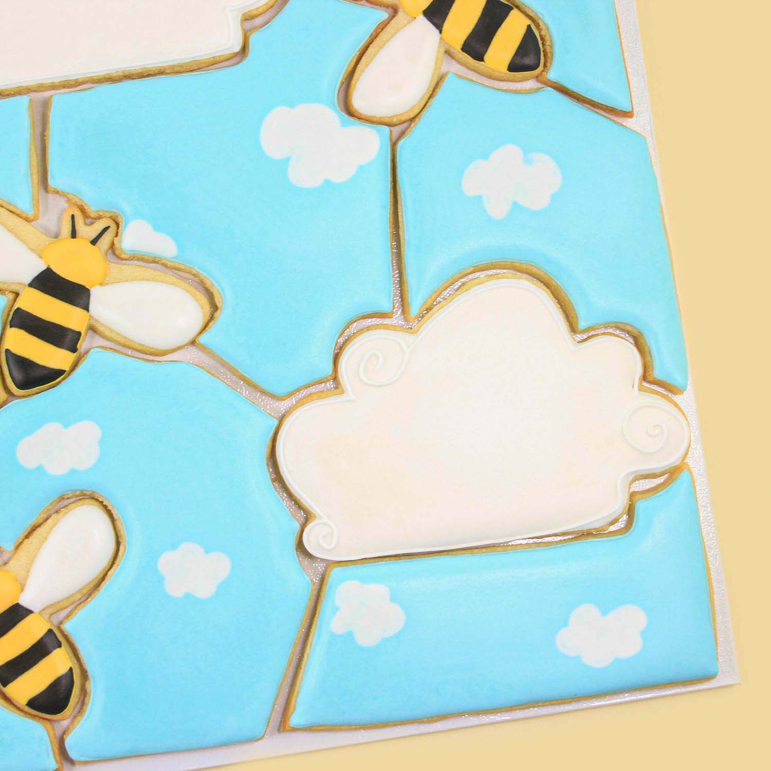 Bumblebee Cookie Puzzle of cloud and bee's decorated in royal icing.