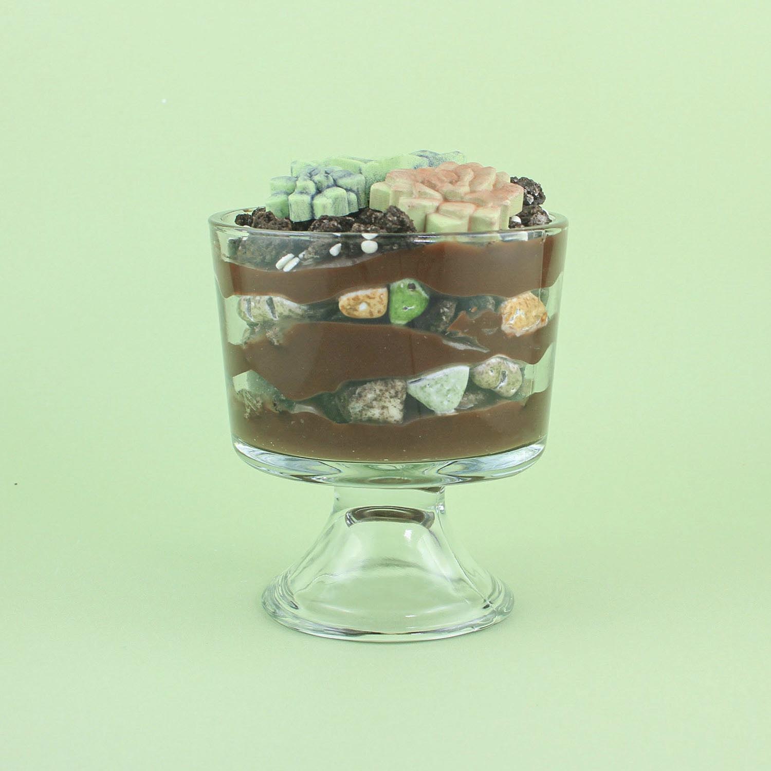 dessert dirt cups showing the layers of chocolate bavarian pastry filling, oreo pieces and candy rocks in a trifle bowl.