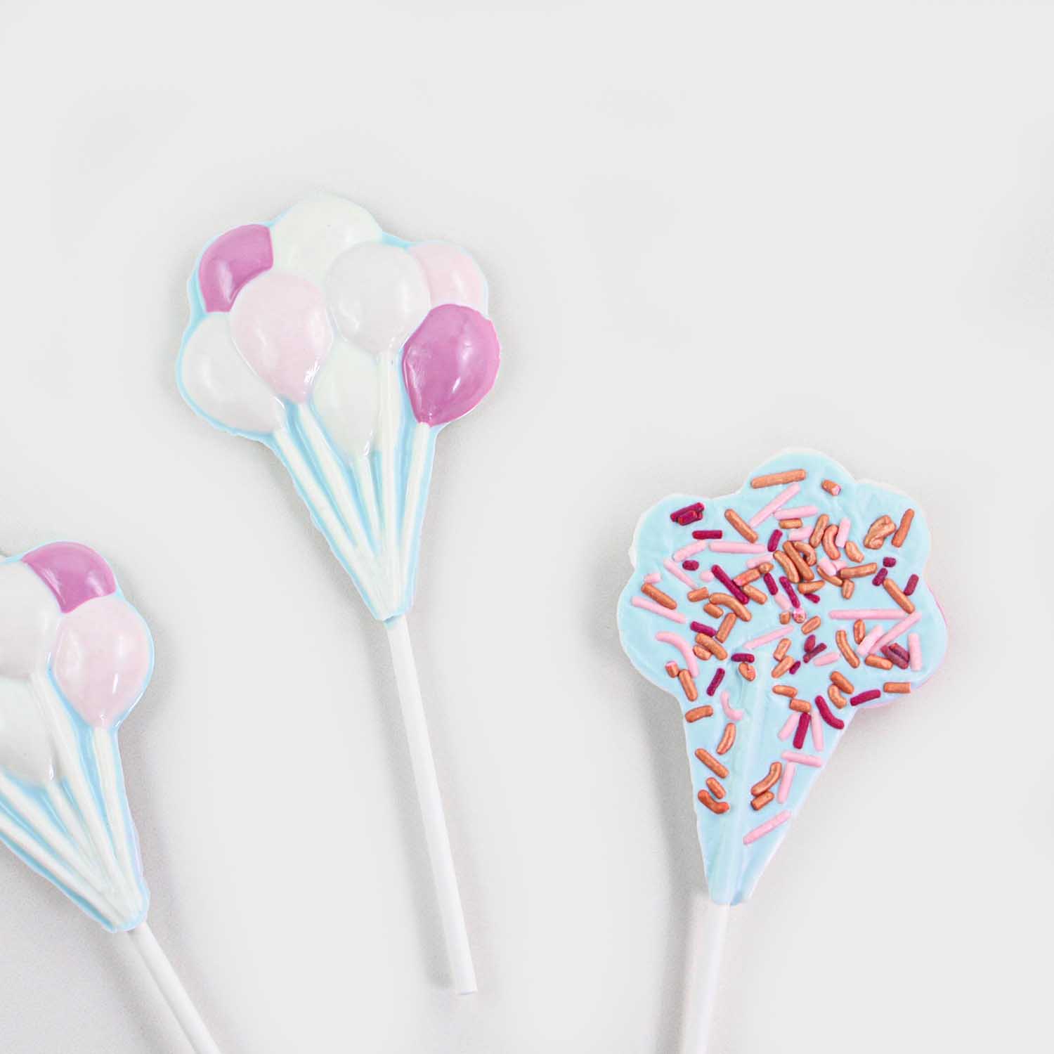 Bunch of ballons chocolate molded sucker in shades of pink with pink, maroon and rose gold jimmies on the back.