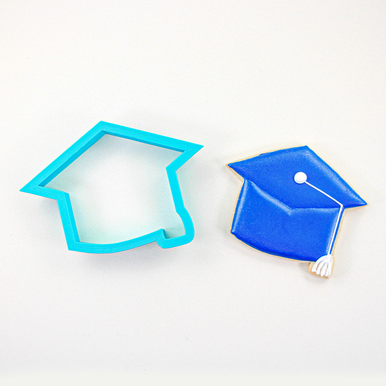 Graduation cap sugar cookie decorated in royal blue icing.