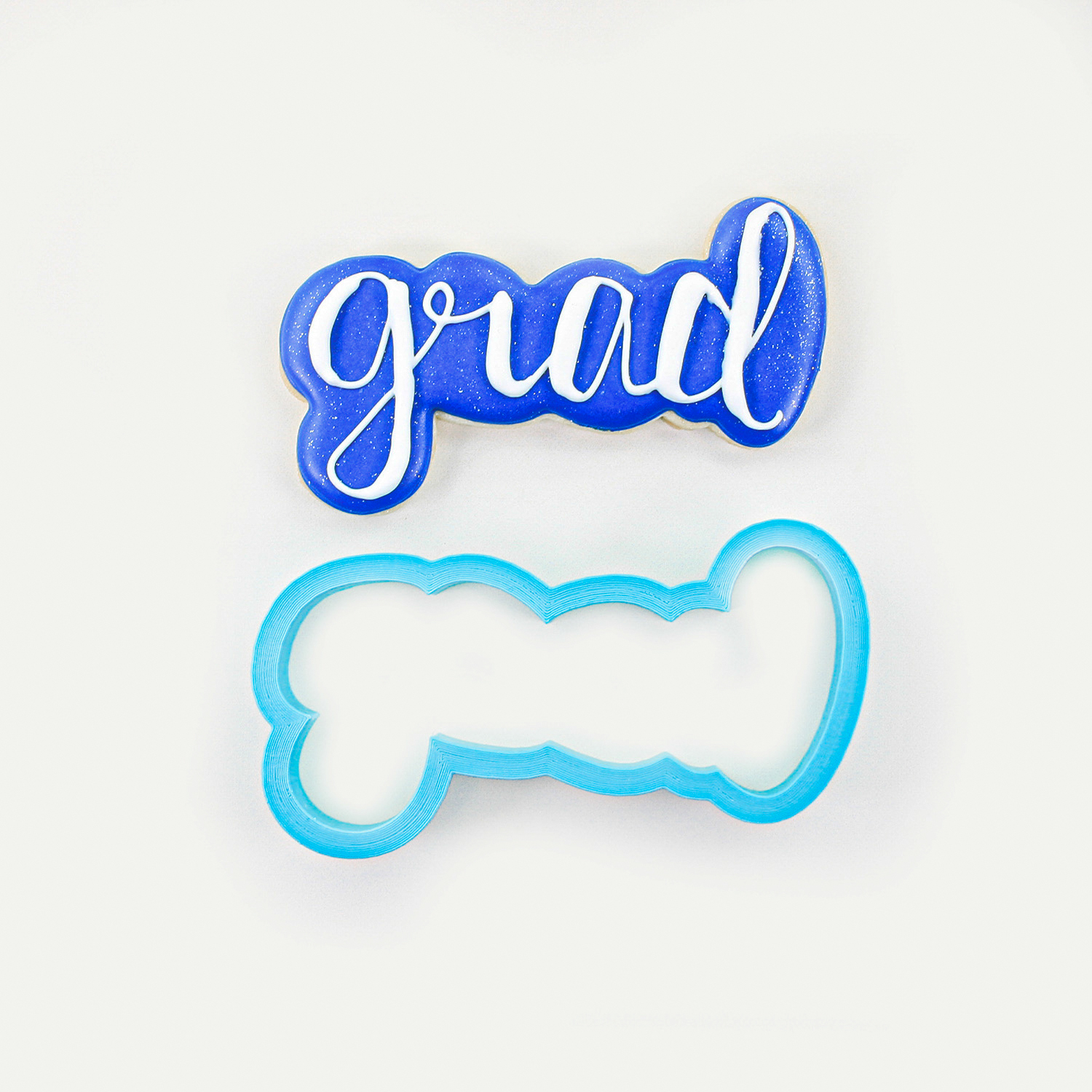 Grad Plaque sugar cookie decorated in royal blue royal icing with white writing.