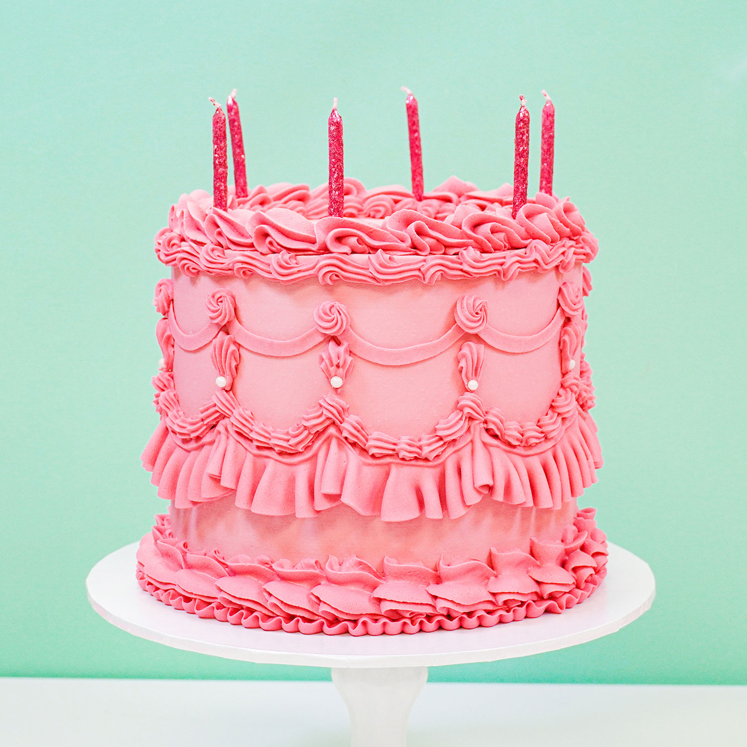 pink vintage cake with a lot of piping and ruffles