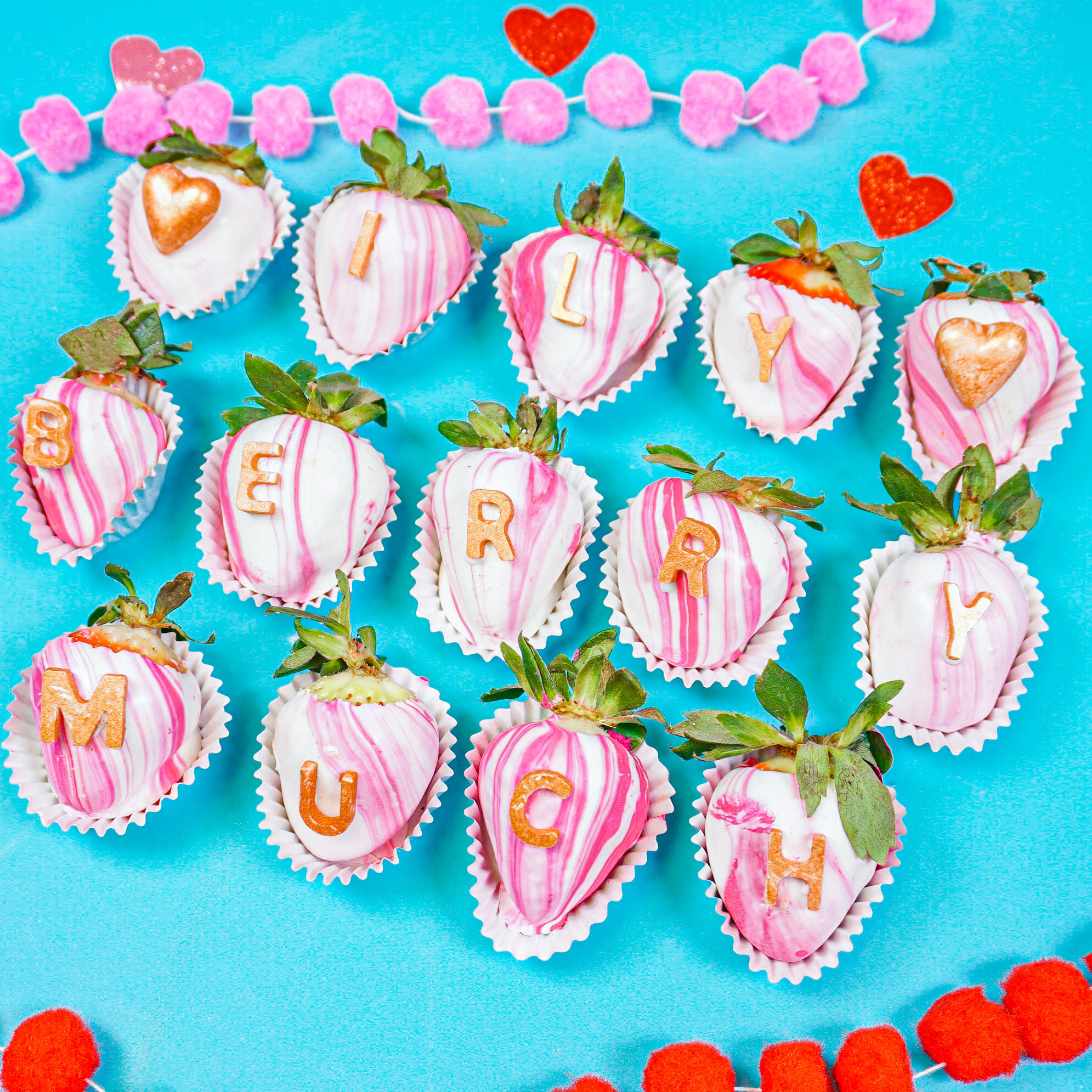 marbled pink chocolate covered strawberries with chocolate letters spelling out "ILY berry much"