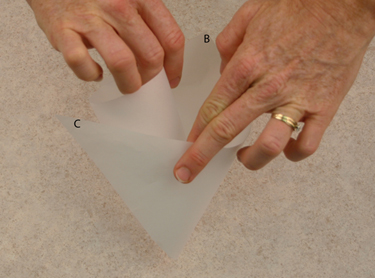 folding parchment triangle into piping bag