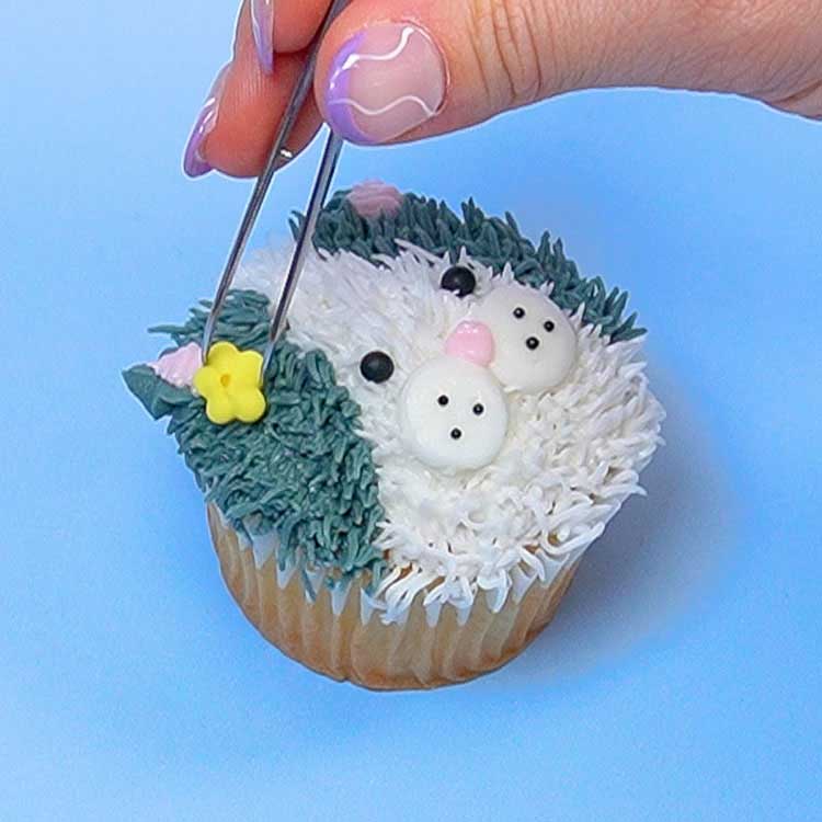 adding sugar flower to kitten cupcake