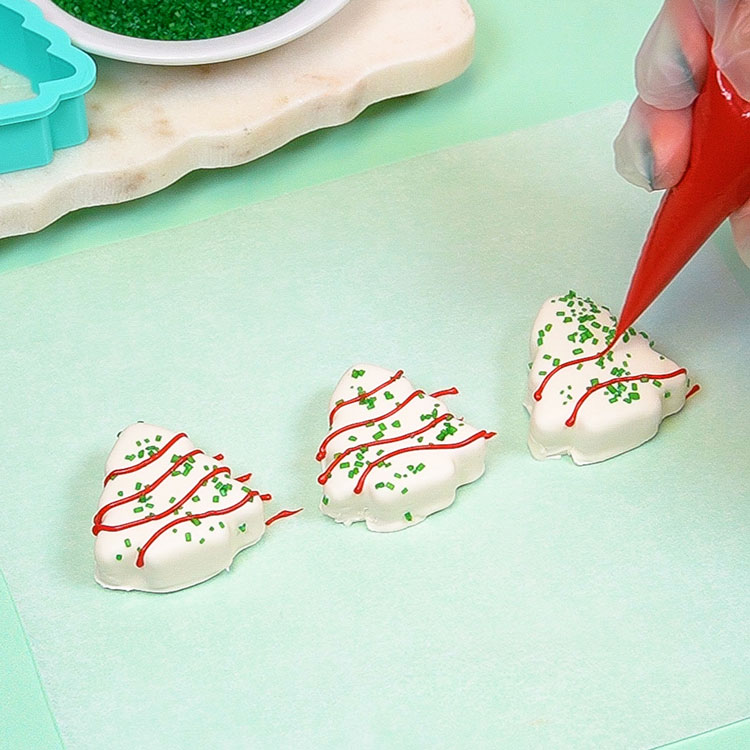 decorating christmas tree cake pops with red chocolate