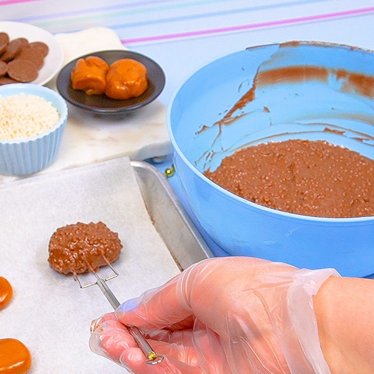 placing dipped caramel onto parchment paper