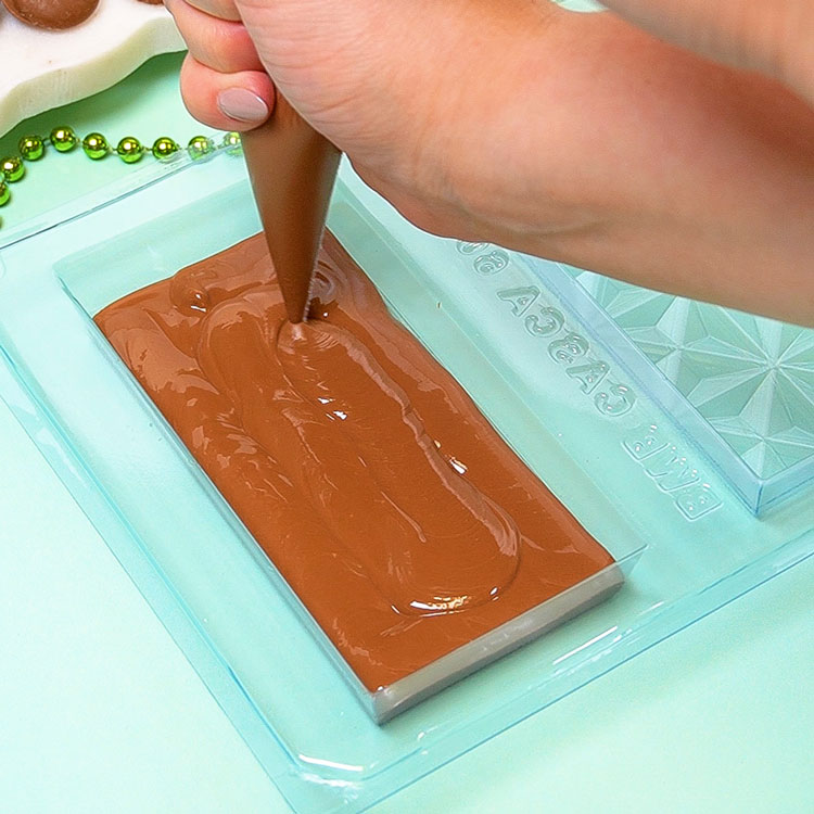 piping milk chocolate in 3 part mold