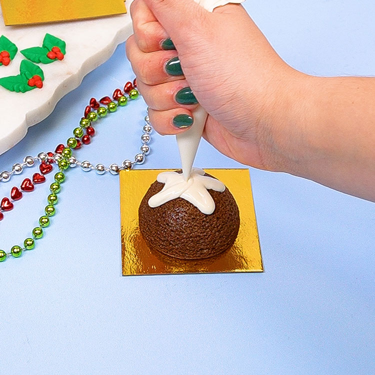 adding white chocolate ganache to mini gingerbread cake