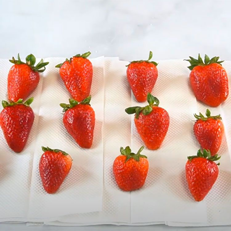 washed strawberries sitting on paper towels to dry