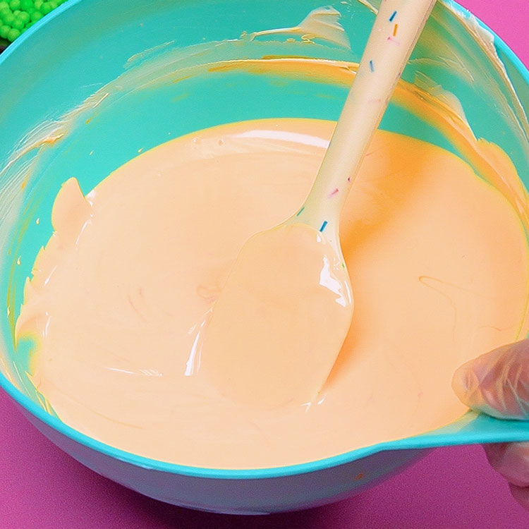 adding rolkem food coloring to melted white chocolate