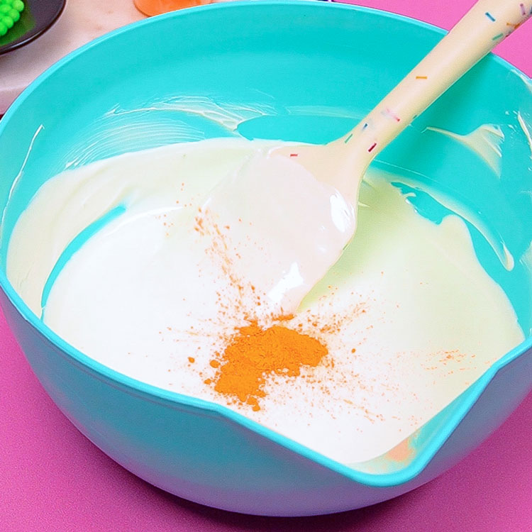 adding rolkem food coloring to melted white chocolate