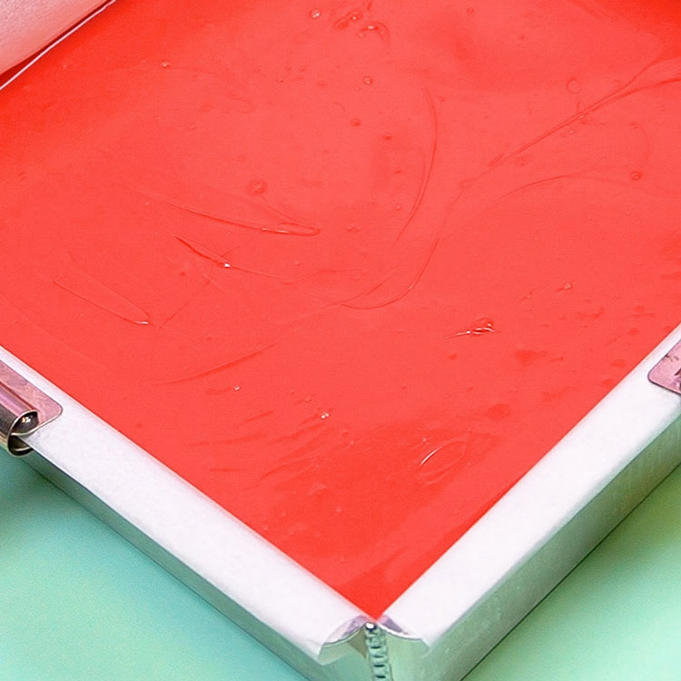 pouring melted red chocolate into cake pan