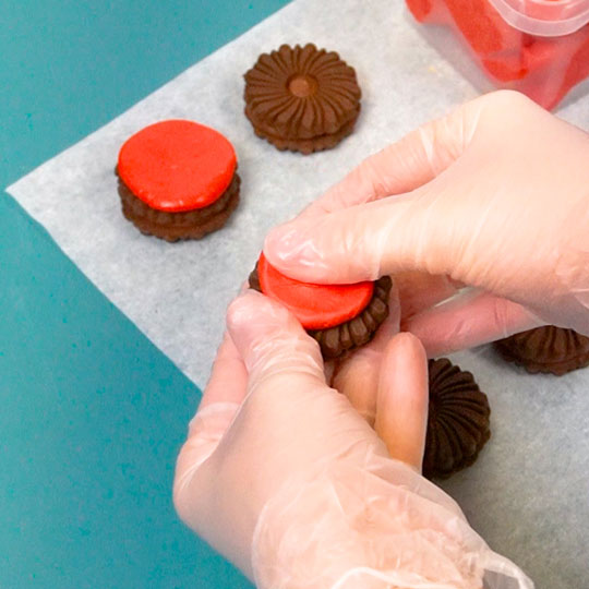 pressing candy center onto oreo cookie