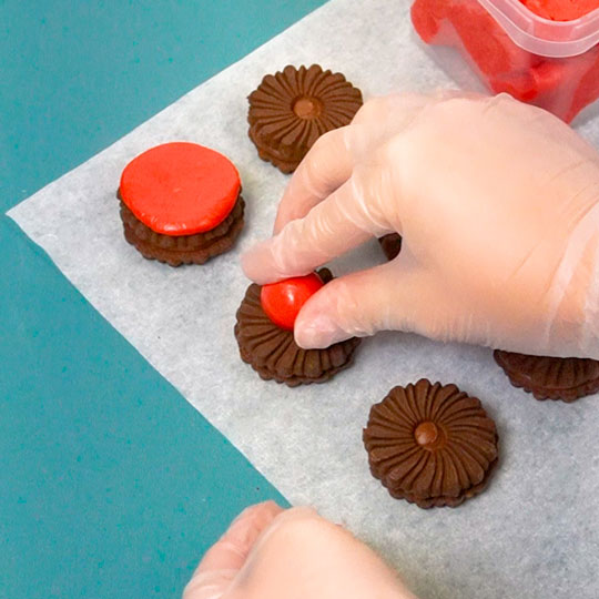 putting candy center onto oreo cookie