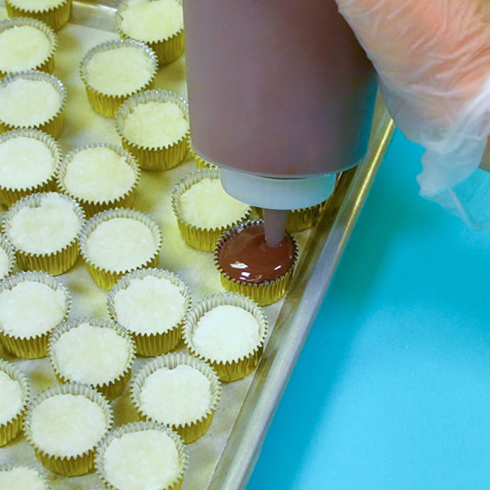 covering coconut dough with melted dark chocolate