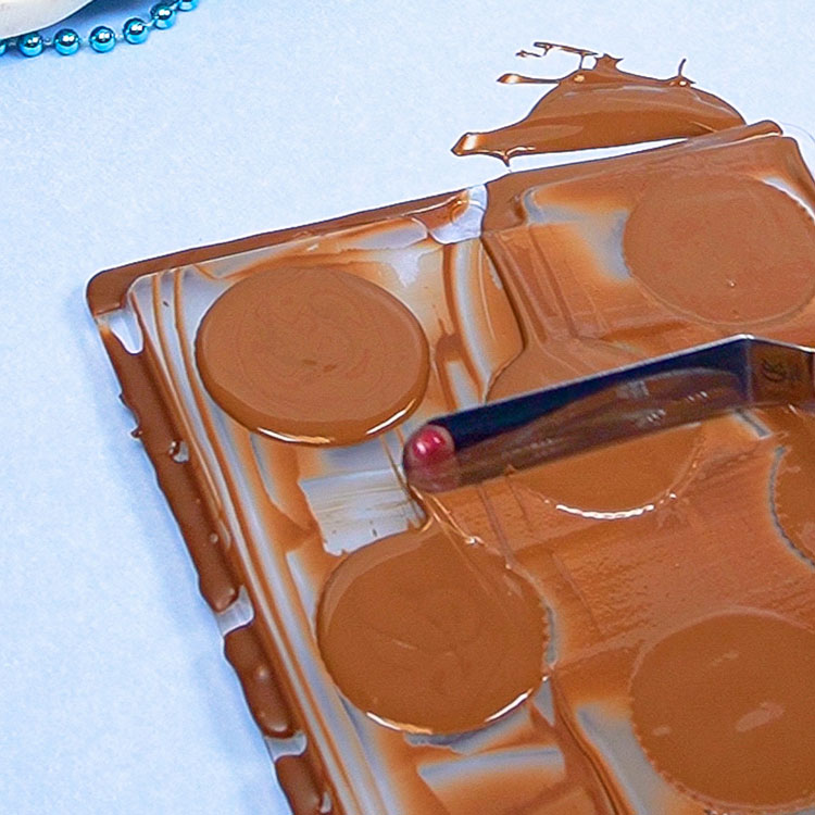 removing excess chocolate from the top of the mold