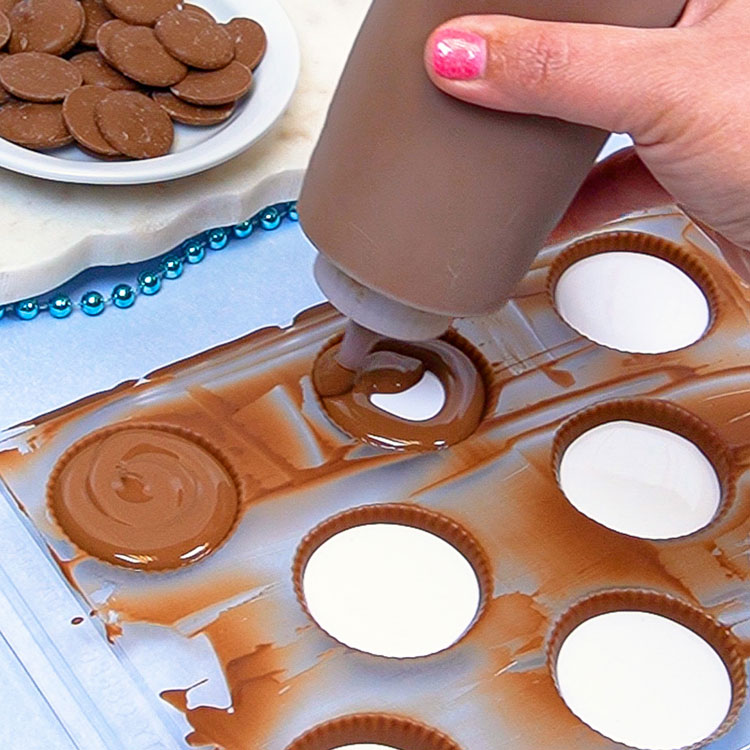 sealing marshmallow filled chocolate shells with more melted chocolate