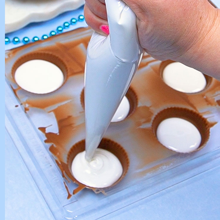 piping homemade marshmallow fluff into chocolate shells