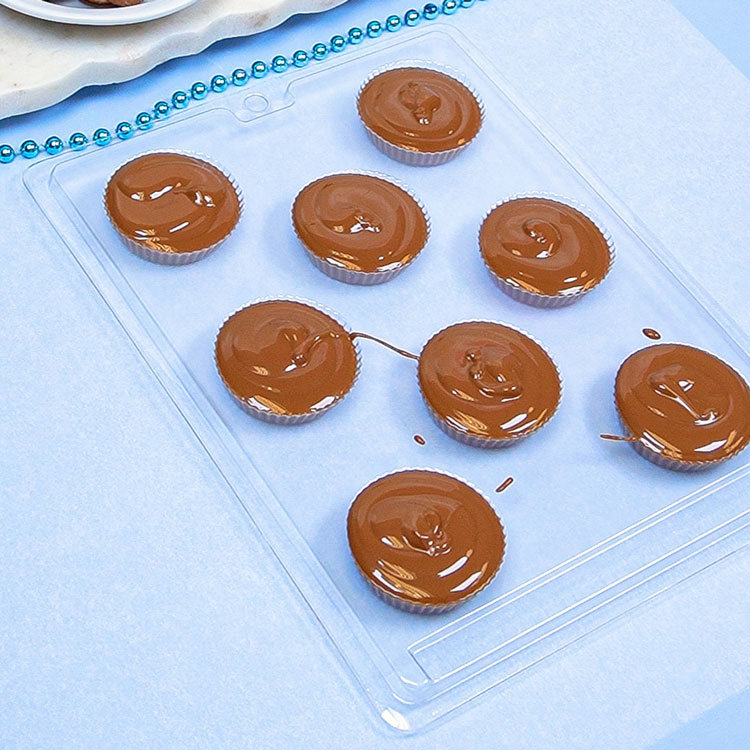 filling candy cup chocolate mold with melted chocolate