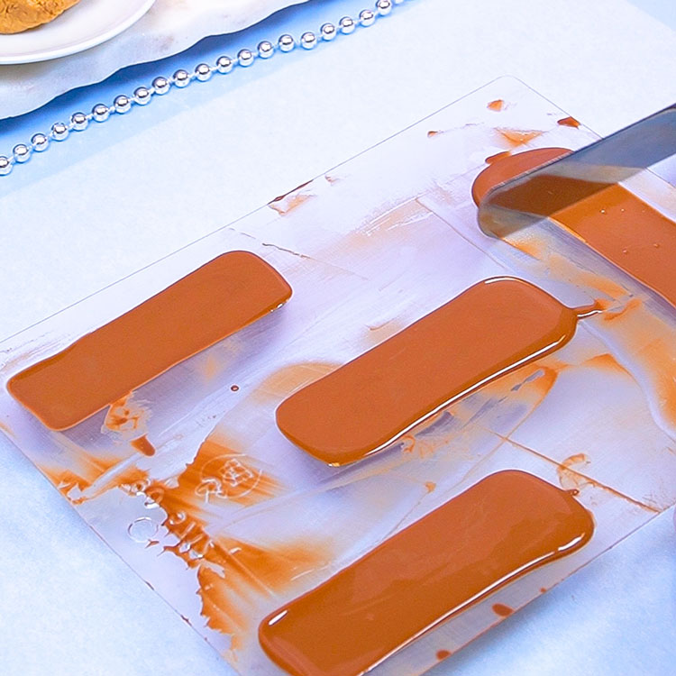 smoothing the backs of each candy bar with angled spatula