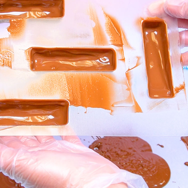 scraping excess chocolate off the mold