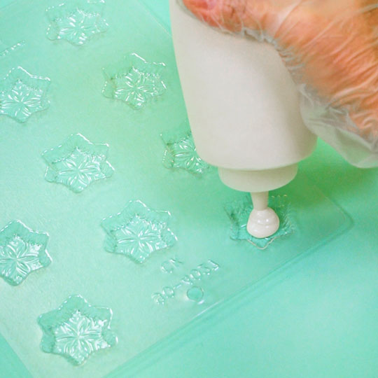 adding melted chocolate into chocolate mold