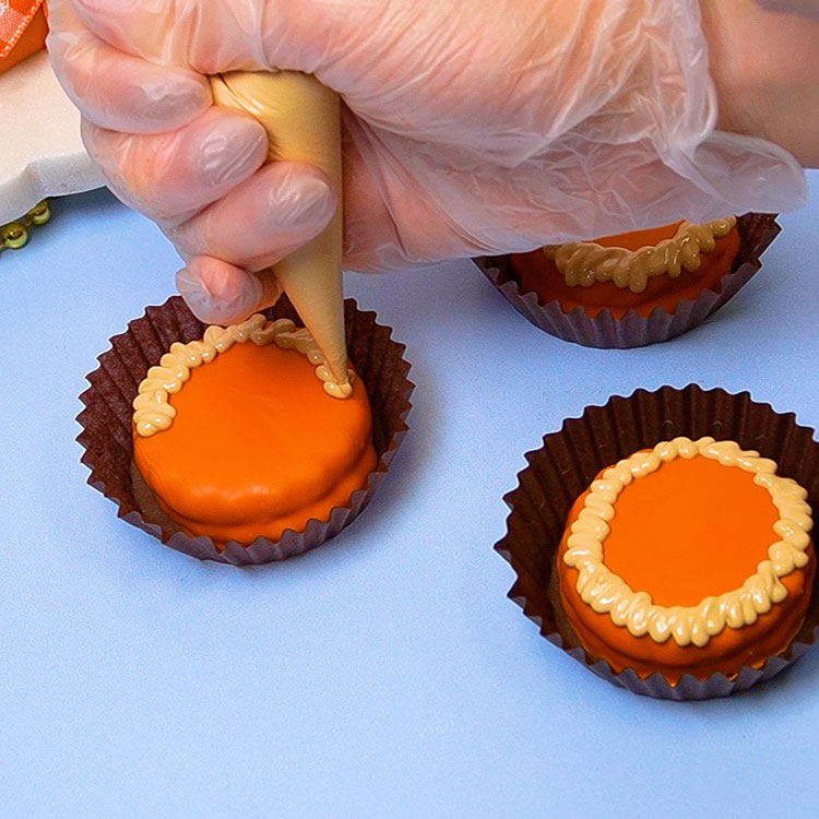 piping chocolate pie crust on dipped cookie