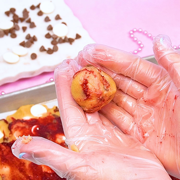 rolling cookie dough scoop into a ball