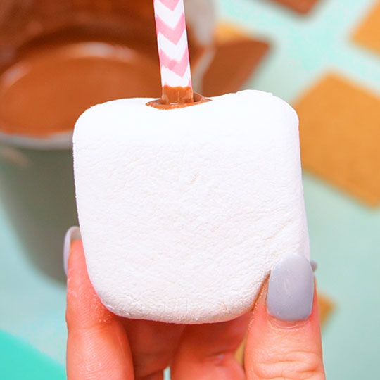 pushing straw into square marshmallow